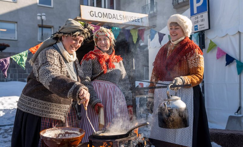 Tre glade damer koker kaffe på bål under Grundsetmartn.