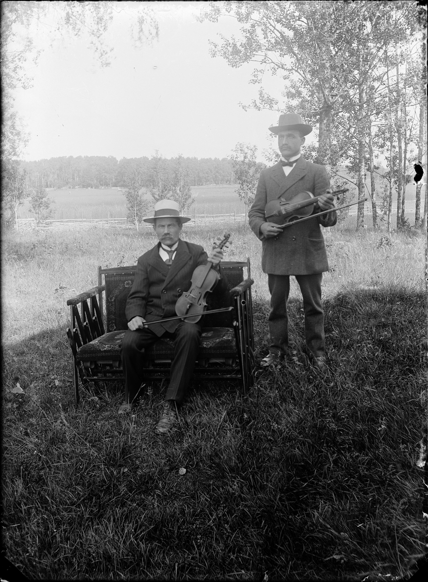 Två män med fiol i trädgård, Alunda, Uppland