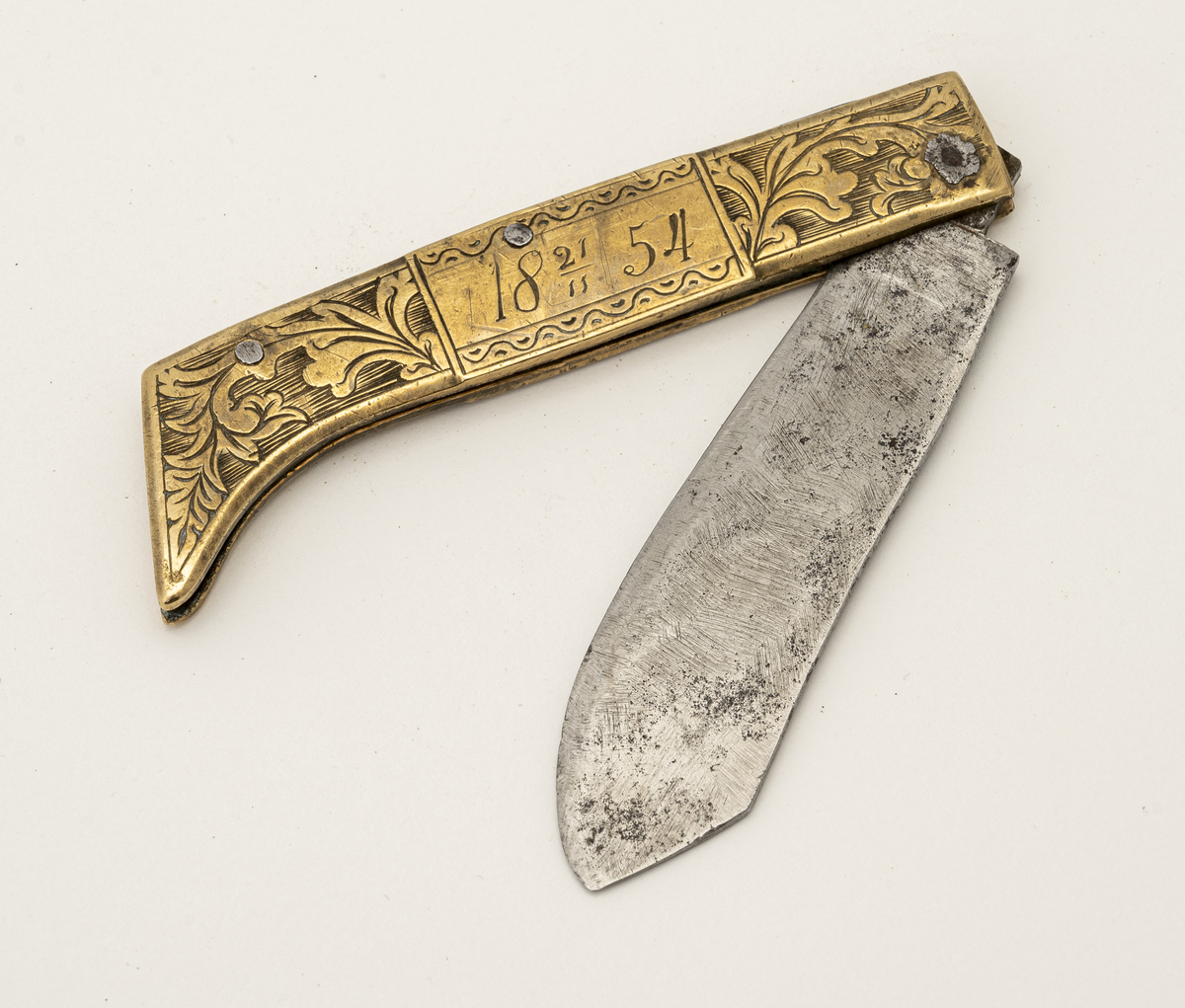 Foldekniv med ornert messingskaft, dekorert med motiv av ranker på riflet bunn og bølgete streker med prikker