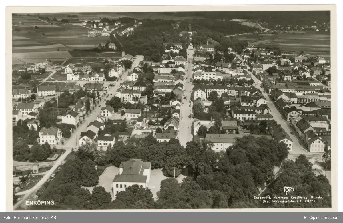 Vykort med flygfoto över Enköping, före den 20/4- 1944. I mitten längst upp ser vi Vårfrukyrkan. De tre parallella gatorna i bild är från vänster till höger: Västra Ringgatan, Kyrkogatan, Kungsgatan. Poststämplat den 20/4- 1944.