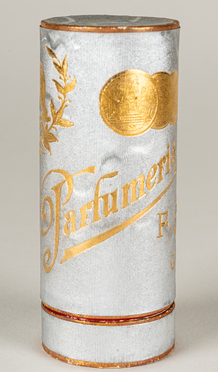 Pappersask för parfymflaska, cylinderformad. Asken i silverton med guldfärgat tryck.