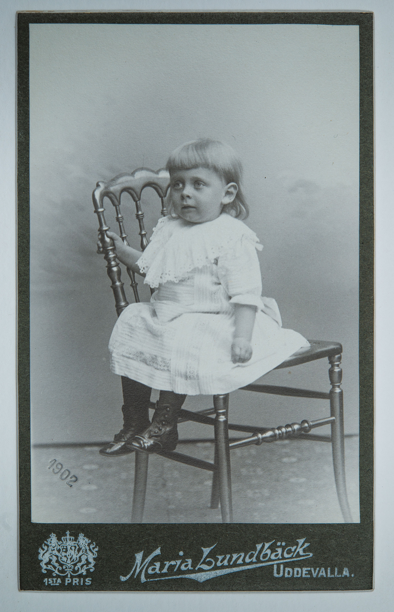 Visitkortsporträtt av Frank Zachau som barn. Fotografiet sitter i fotoalbum som tillhört Gertrud Zachau. Fotografiet sitter på sida 24.