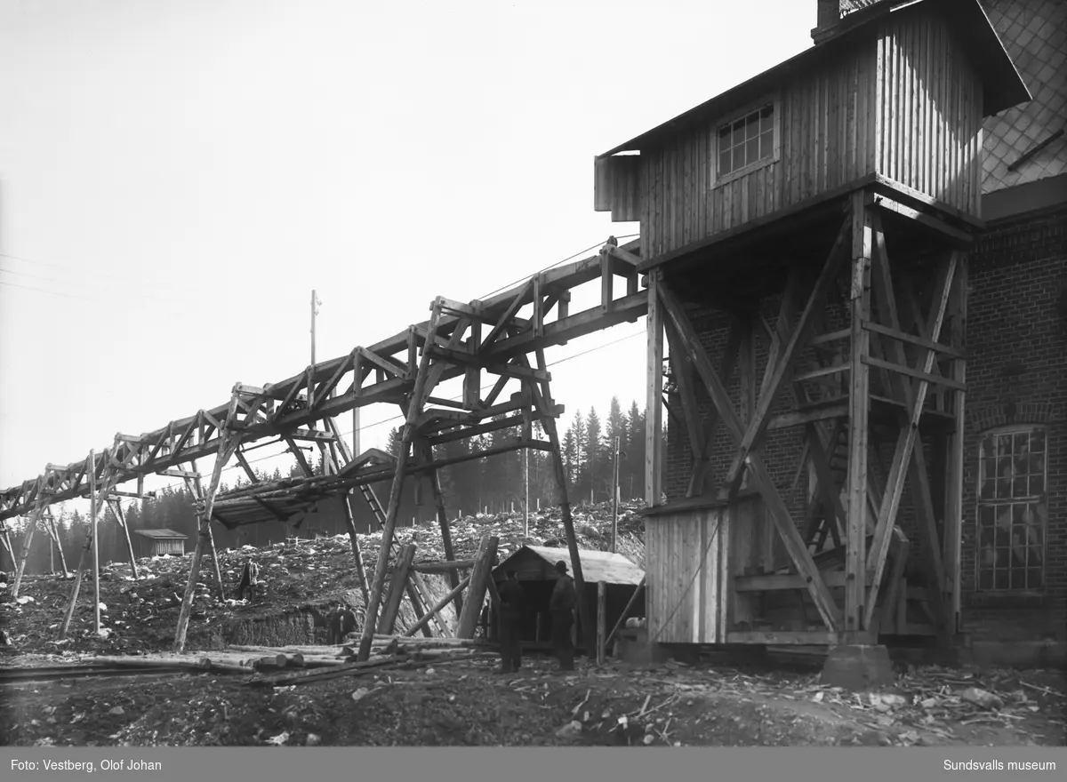 Två bilder av en anordning för att lyfta och förflytta virke vid Essviks sulfitfabrik.