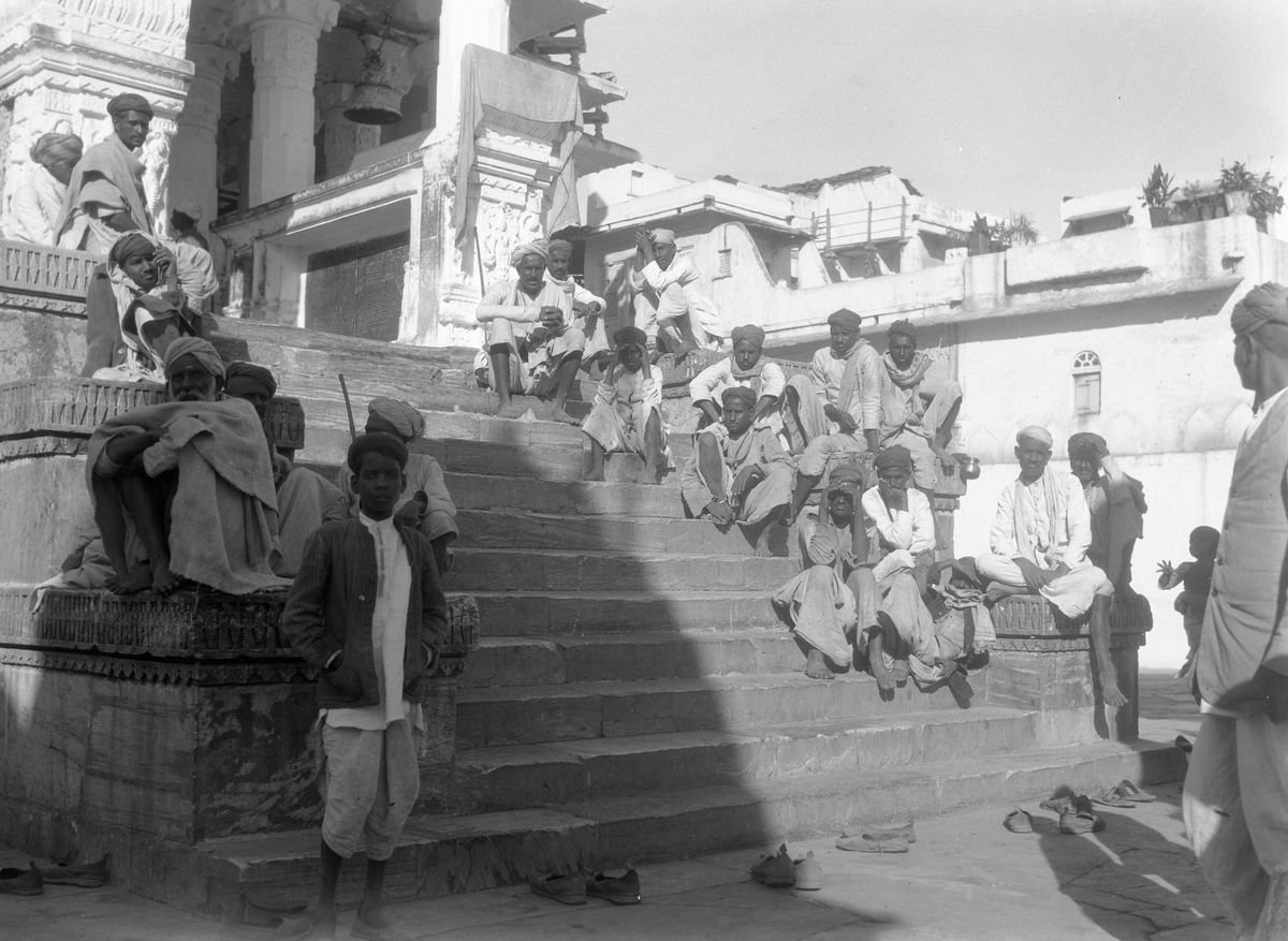En gruppe menn sitter på en trapp, Udaipur. Fotografi tatt i forbindelse med Elisabeth Meyers reise til India 1932-33.