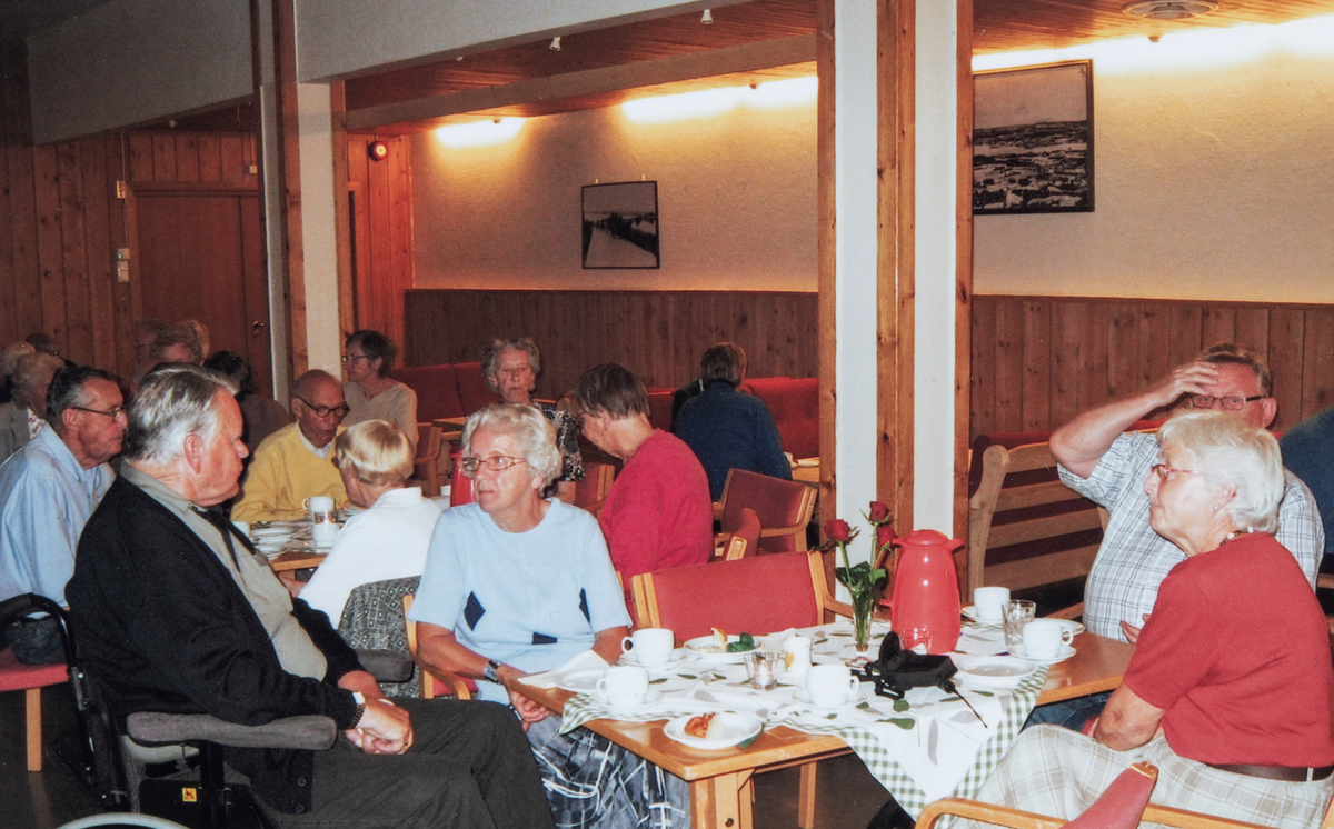 Kaffekos på medlemsmøte i Ottestad pensjonistforening den 2. september 2008. Til venstre, med mørk jakke: Leiv Pedersen. Damen med lyseblå genser midt i bildet er foreningens sekretær: Gerd Pedersen.