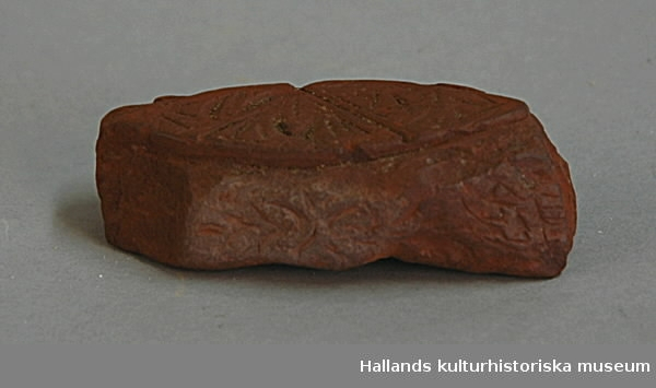 Arkeologiskt föremål. Ornerat stycke av hårdbränt lergods. "Anno 1548".