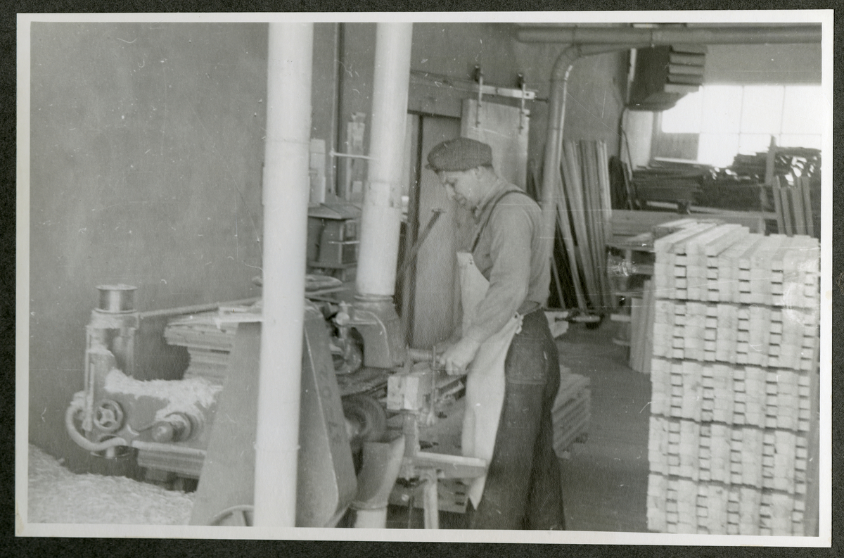 Foto av tremateriale og mann med maskineri ved  Aall-Ulefoss Brugs Dørfabrikk