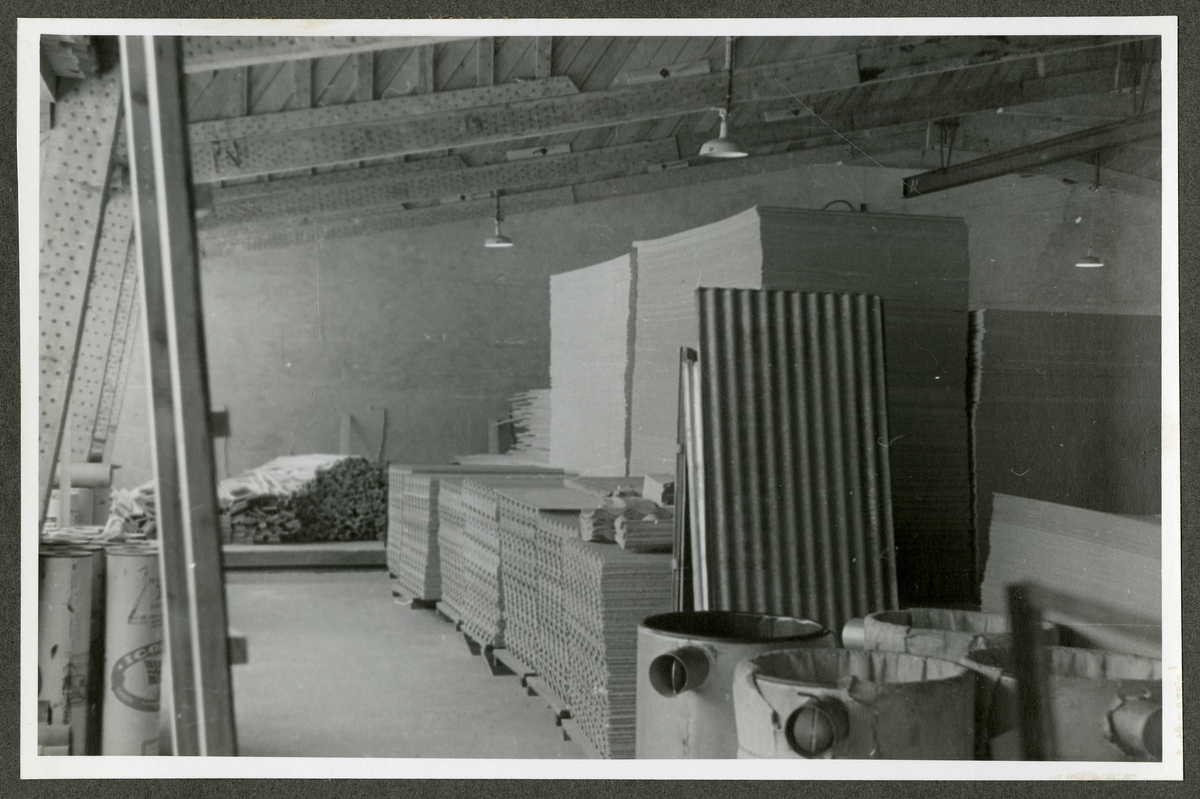 Foto av lager fylt med tremateriale på paller, antagelig på Aall-Ulfeos Brugs dørfabrikk