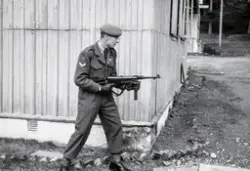 Korporal Odd Aspeli i militæruniform og med våpen, maskinpis