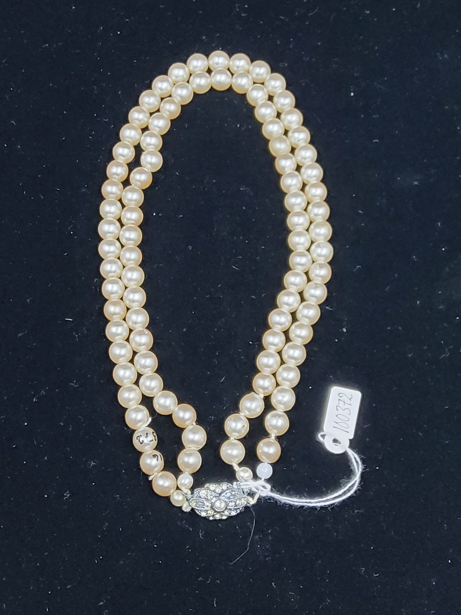Halsband av pärlemor-belagda glaspärlor med lås av försilvrad mässing och prydd med små slipade glasstenar. Dubbla rader.