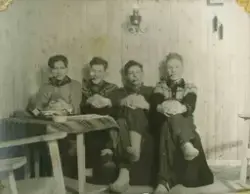Fire unge menn poserer med pipe. De sitter i noe som ligner 