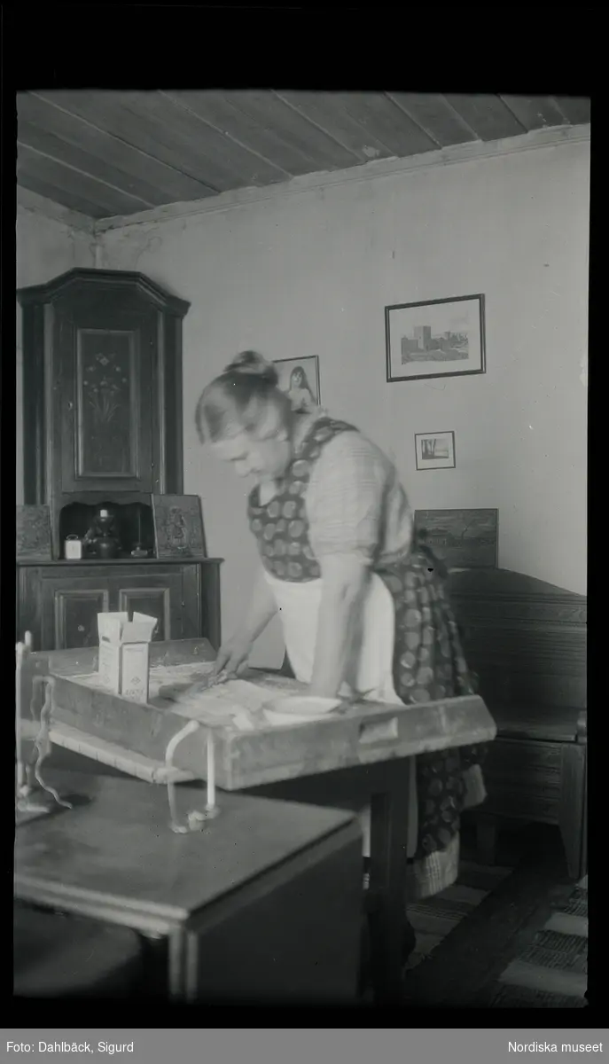 En kvinna står och bakar på ett bakbord.
