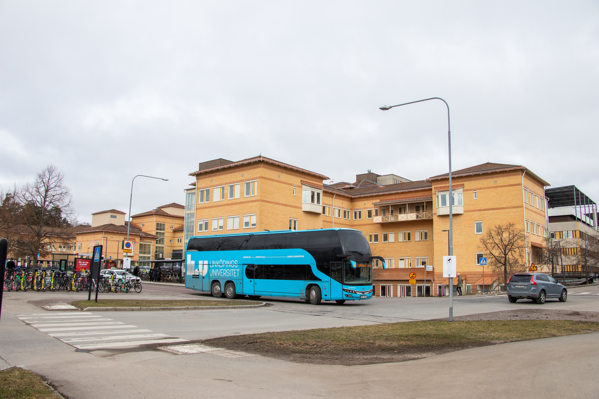 En buss passerar Södra entrén på US i Linköping. Bussen går mot Linköpings universitet. Bussen för studenter färdas mellan Linköpings universitet, Hälsouniversitetet på US och Campus Norrköping. Sjukhus. Buss. 
Bilder från staden Linköping år 2024 som en del av en samtidsdokumentation för Linköpings kommun.