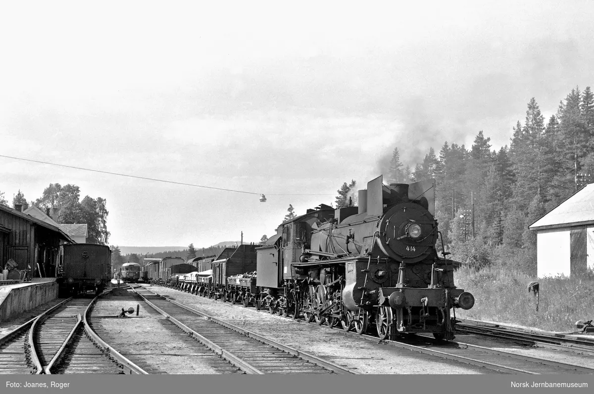 Godstog til Tynset på Rena stasjon. Toget trekkes av damplokomotiv type 26c nr. 414. Godstog til Hamar i spor 3, kryssende persontog i spor 1.