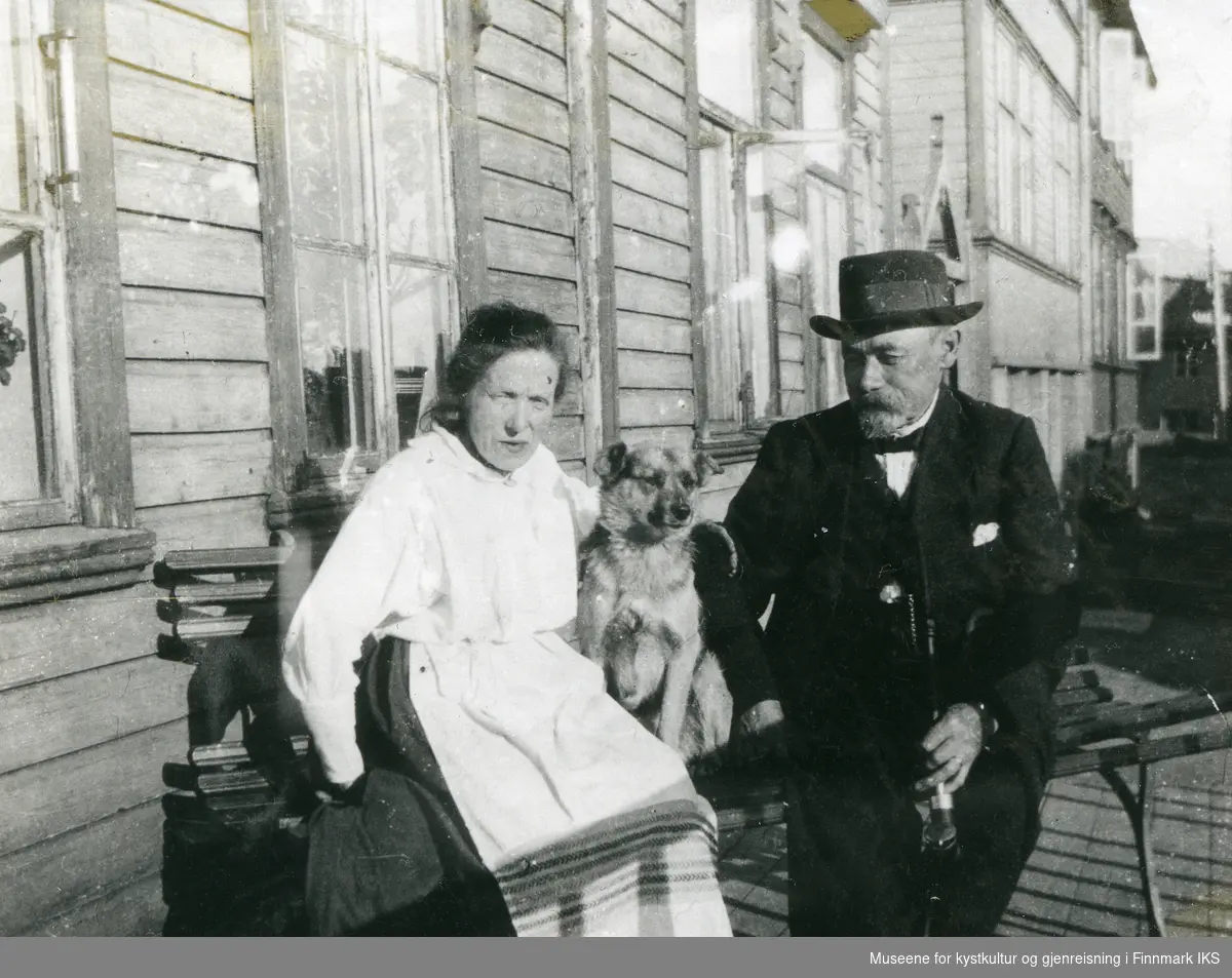 Honningsvåg. Ole Christian Løkke og kona Emilie med hunden på en benk foran huset. 1930-tallet.