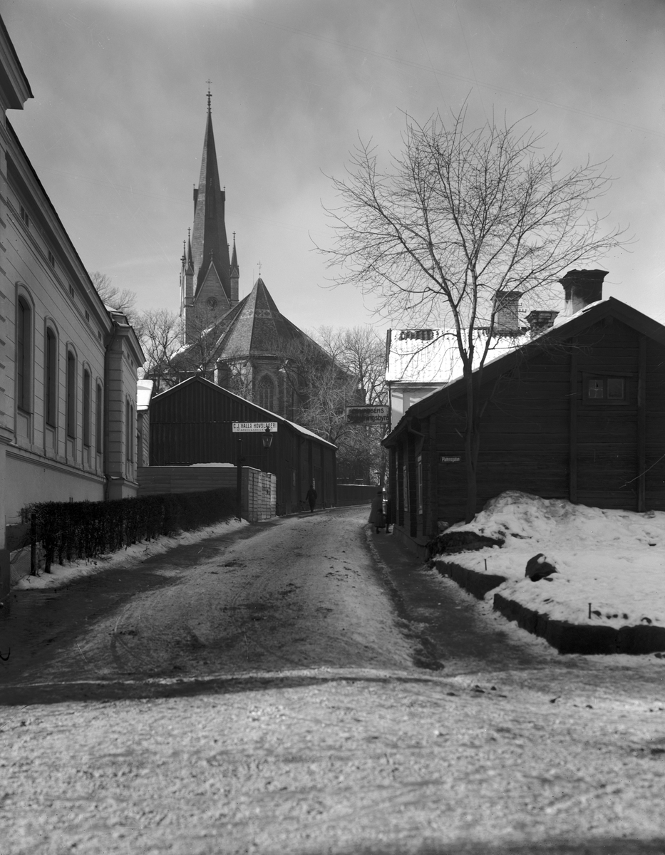 Den lågt stående vintersolen lämnade Ågatan i dunkel när Linköpingsfotografen Stenhardt ställde upp sin utrustning vid gatans korsning med Platensgatan. Resultatet får beskrivas som stämningsfullt med stiftets dom som belyst fond. Närmast till vänster skymtar Hypoteksgården, där Östergötlands museum var inrymt från 1922. Kvarteret Absalon till höger kom från 1927 att saneras och kraftigt omdanas. Foto omkring 1925.