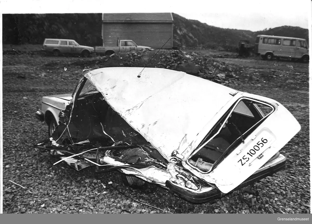 Trafikkulykke ved knuser 31.08.1983. Ulykkesstedet med skadet bil og dumper. Ulykkesbilen var en Volvo som ble påkjørt av en lastebil stor dumper av typen Lectra Haul, som var en del av A/S Sydvaranger sin maskinpark. Skadene på bilden viser tydelig hvor lastebilens hjul har trykt ned på bilens flanke.