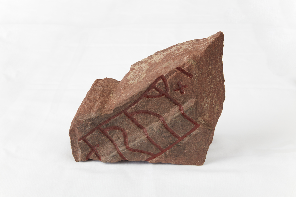 Runstensfragment av rödaktig kvartsitisk sandsten. 
Runornas storlek är 95 mm. Ristningen är djup och tydlig. Inskrift: ....orum x 5. 
Fragmentets baksida har tydliga slingor. Runformer och huggningsteknik ge vid handen att fragmentet tillhör 1000-talet.