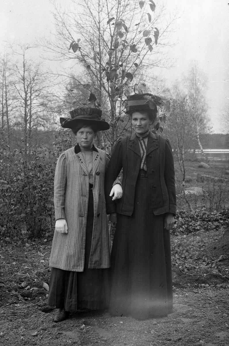Två damer i stora hattar