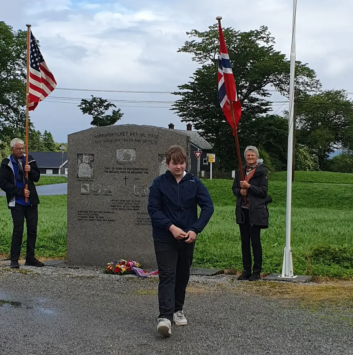 Norrønamonumentet med flaggvakt, USA og Norsk flagg. Ein ungdom har nettopp lagt ned krans ved monumentet