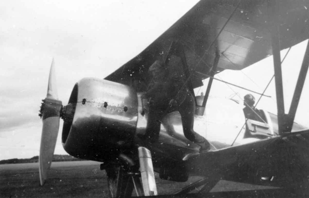 Fly som har landet på Gardemoen. Flygeren i cockpit og en mann på vingen.