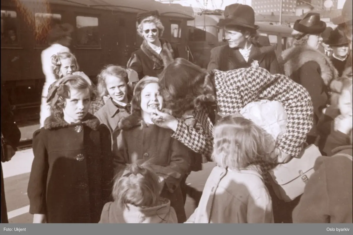 Oslo menighetspleiers fellesutvalg formidlet innbydelser og organiserte barnereiser under okkupasjonen. Barna fikk komme på landet "å fete seg opp". De ble sendt til bygder rundt i hele Sør-Norge. Vel tilbake på Vestbanestasjonen i Oslo. En tann er felt under landoppholdet.