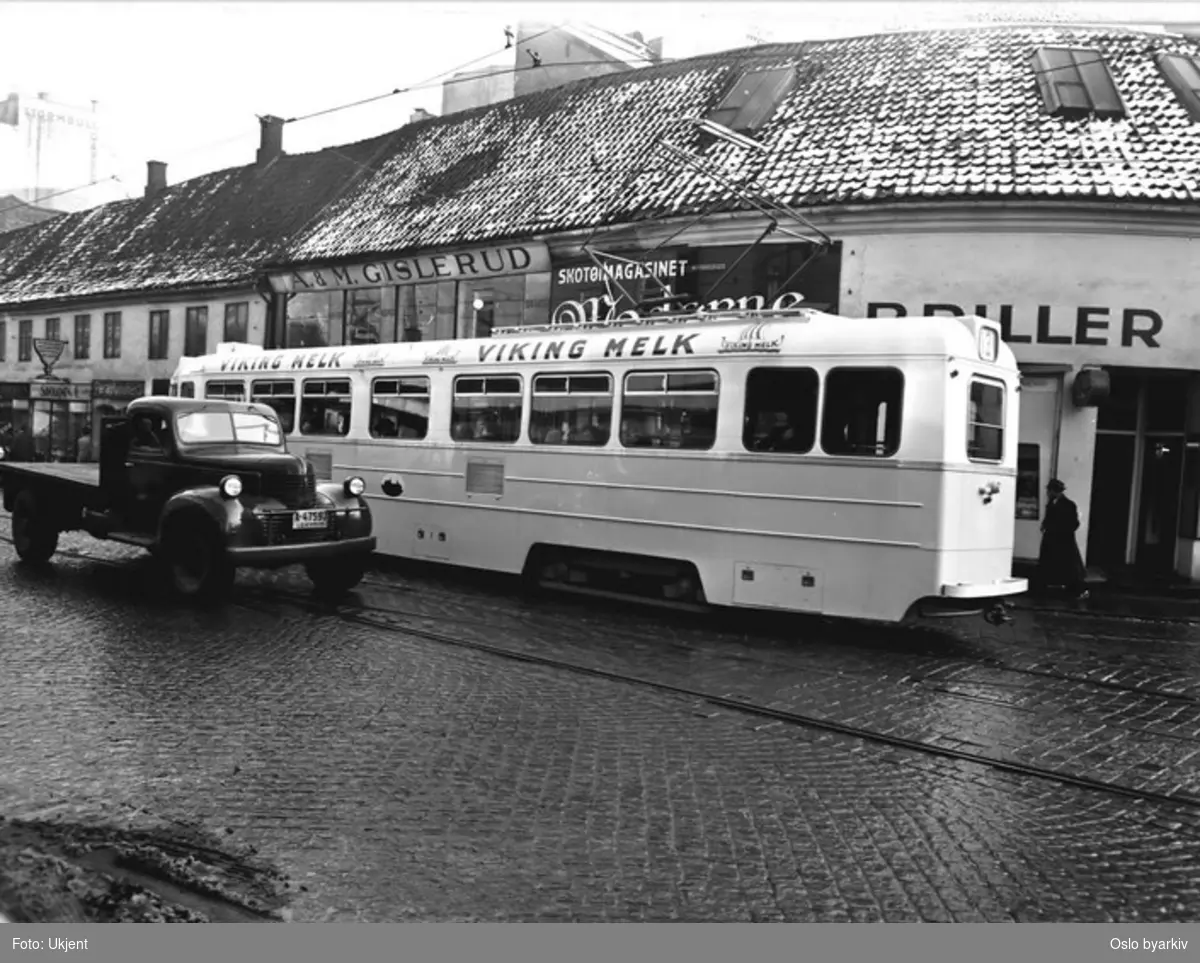 Oslo Sporveier. Trikk motorvogn 204 type Høka MBO linje 13, i bakgrunnen de lave husene på hjørnet av Dronningens gate - Storgata, de ble revet da NAF-huset skulle bygges. Lastebil, butikkskilt.