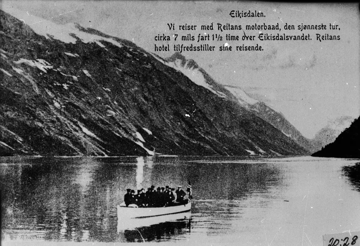 Eikesdalsvatnet, turister i Reitans båt., før 1911..Med båten "Romsdal", navnet på båten er retusjert bort på postkortutgaven.."Vi reiser med Reitans motorbåt, den sjønneste tur, ca 7 mils fart 1,5 time over Eikesdalsvantnet. Reitans hotel tilfredstiller sine reisende.".