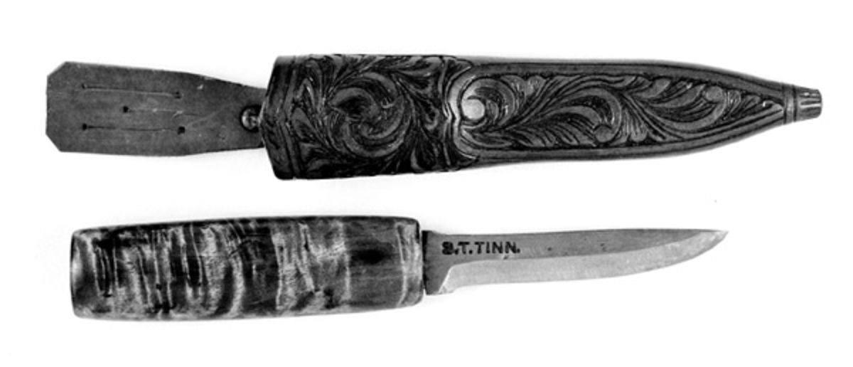 Tolleknv i slire. Knivbladet er smidd av Svein Svimbil (1888-1987) fra Tinn mens det er Emil Flåstøyl (1896-1984) som har vært mester for skaft og slire. Flaten skal ha ferdigstilt denne kniven i 1979.

Kniven er 19,6 centimeter lang, målt fra bladspissen til den bakre enden av skaftet. Bladdelen er 9,3 centimeter lang. Bredden, målt ved brystningen, er 1,9 centimeter. Her er det imidlertid en profilert forhøyning, en «krull» eller «smellopp» på bladryggen. Framfor denne er bladbredden cirka 1,5 centimeter. Tjukkelsen på bladet, målt innerst på bladet, er 4,3 millimeter. Den bakre delen av bladryggen er rettlinjet, mens den fremre delen buer en aning nedover mot bladspissen. Smeden har stemplet inn initialer og adresse - «S.T.TINN» - bakerst på det som når kniven holdes i arbeidsstilling er den venstre sidseflata. T-en i «S.T.» står for Tverberg, som var etternavnet smeden brukte før han flyttet til bruket Svimbil. Skaftet lagd av flammet bjørkevirke. Det er rett, konvekst i lengderetningen og ovalt i tverrsnitt. Største tverrsnitt er 2,1 X 3,0 centimeter. Skaftet er brunbeiset og innsatt med blank klarlakk. 

Slira er sydd av om lag 3,6 millimeter tjukt brunfarget lær. Den er rett og symmetrisk om midtaksen i lengderetningen. Sliresømmen er plassert på den sida som vil vende inn mot kroppen når knivstellet bæres i beltet. Lengden er 16,7 centimeter. Opphenget er ikke inkludert i dette lengdemålet. Yttermålet ved sliremunningen er 3,6 centimeter. Slira har ingen metallbeslag. Den er imidlertid prydet med utskåren dekor. På forsida er det snakk om akantusranker. På baksida er det bladfliker som tilsynelatende har «vokst» ut med sliresømmen som stengel. Opprinnelig presset Flåstøyl inn motiv i det våte læret med syl eller liknende. Den ferdig dekorerte slira lakkeres først med kvistlakk. Så pusser han den av på overflata og lakkerer over med en blank lakk. På innsida av sliremunningen er det innstukket ei ståltrådhempe som opphenget - en lysebrun lærestrimmel med tre innskårne spalter for feste i et smalt belte eller en knapp i bukselinninga til knivbrukeren.