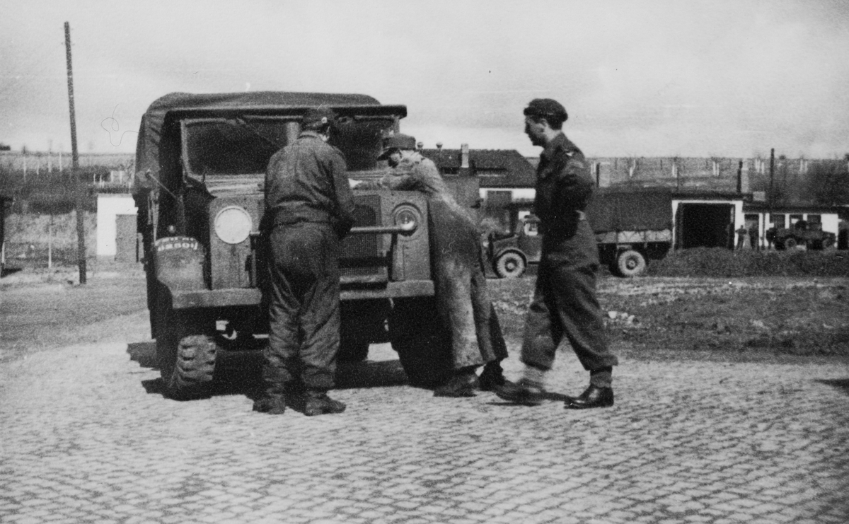 Brigadesoldater sjekker motoren på militært kjøretøy.