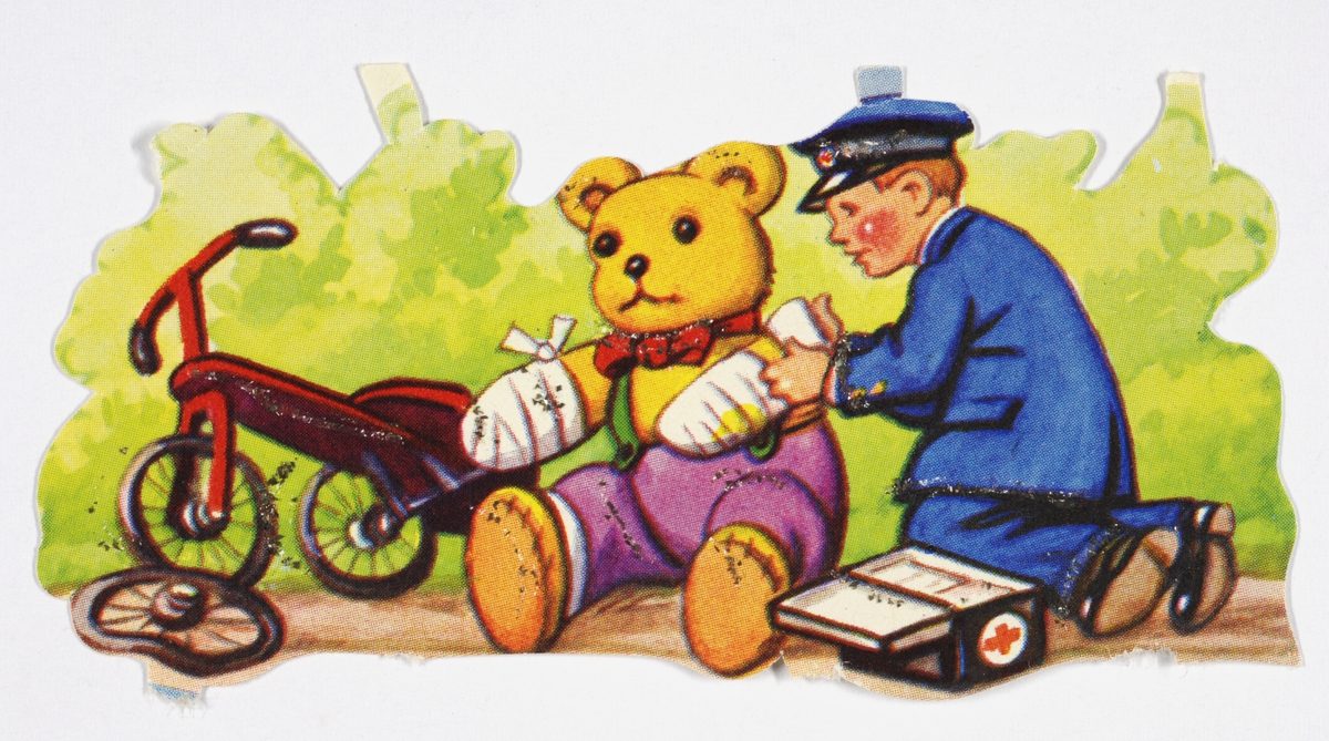 Bilde av en teddybjørn som er bandasjert. Mann i uniform med førstehjelpsskin bansjerer teddybjørnen. Trehjulsykkel med et ødelagt hjul står ved siden av. I bakgrunnen er det skog.
