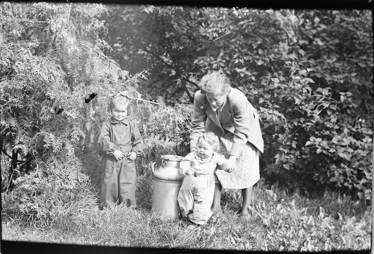 Ingrid Bjørge, Moelv, med barna Inger Johanne til venstre og Trond ved et melkespann. 