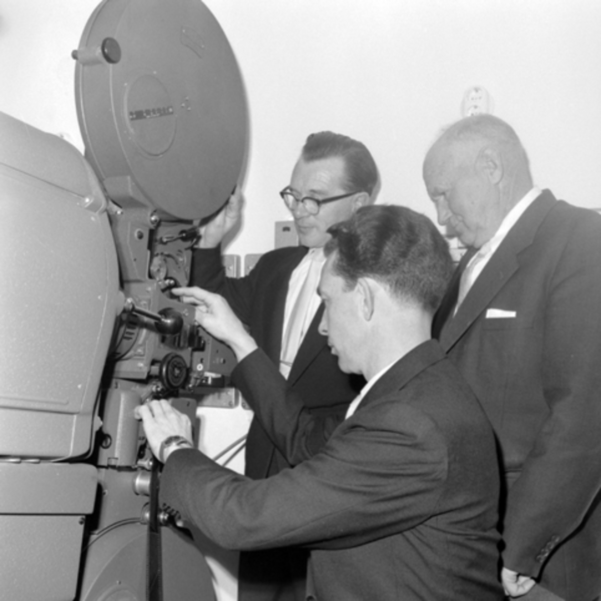 Innvielsen av Tingnes den 18. 11. 1961. Kinomaskin. Det er kinomaskinist Eriksrud som trær filmen. De to øvrige ukjente.