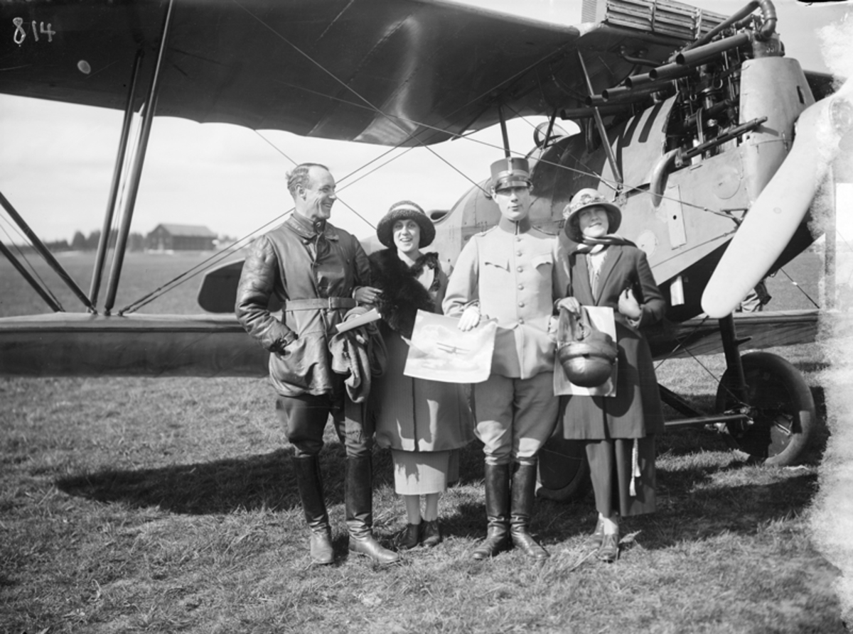 Fyra personer framför flygplan på Malmen. Till vänster en löjtnant och en kvinna och till höger i bild en kapten och en kvinna.