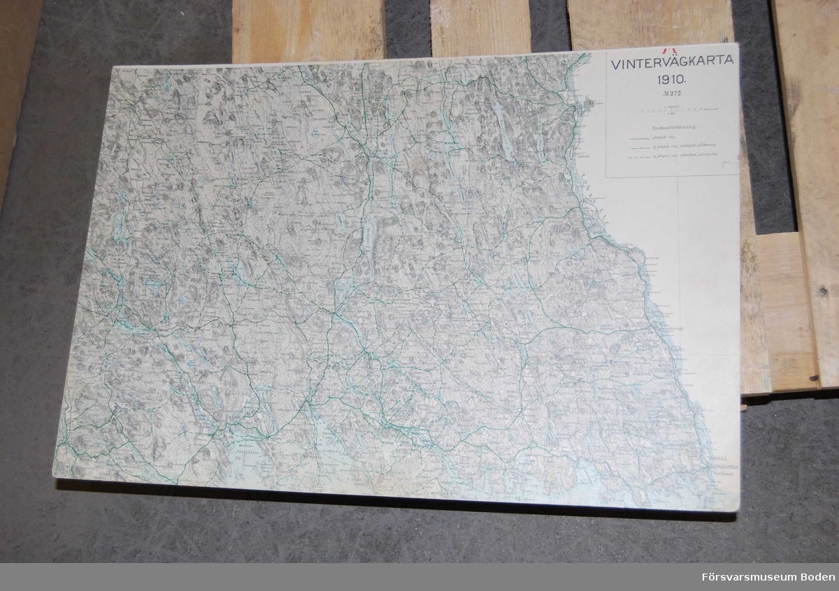 Trälåda innehållande kartblad på styv kartong i skala 1:10000, översiktskartor över sydöstra Norrbotten, vintervägkartor samt spelpjäser. Ska också innehålla bilagshäften, vilka saknas.