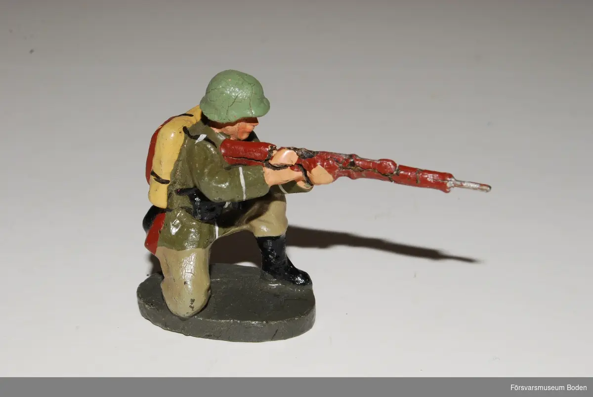 Knästående infanterist med gevär. Av gjutmassa. Tillverkad i Tyskland före 1943.