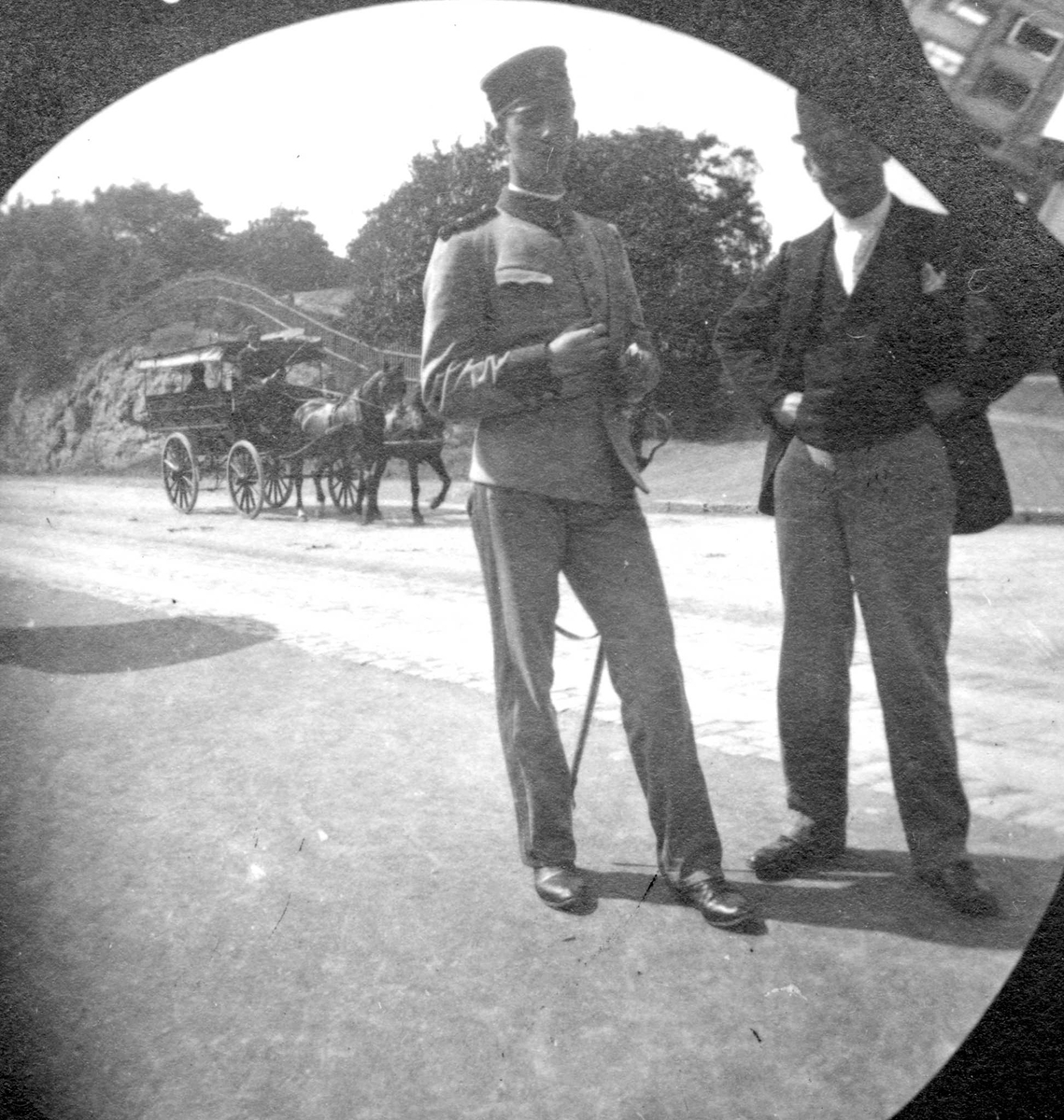Løytnant Hans Hals med uniform og Michael Clauson ved gate, Oslo, med hestekjøretøy. Park på den andre siden av gata. Drammensveien?

