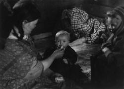 Kautokeinofamilie, en kvinne og to barn i et rom. Kautokeino