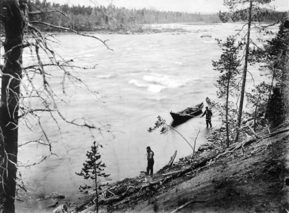 Elvebåt trekkes langs elvebredden av ferdesmann ved Hestfossen eller Bornjeguoikka (på norsk Tangefoss), Sør-Varanger, Finnmark, 1890-årene.