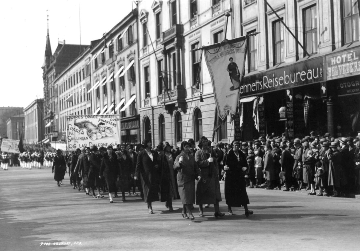 1. mai-demonstrasjon, Karl Johans gate, Oslo, 1930. Oslo kommunale rengjøringskvinner i tog.
Faner og paroler. Tilskuere.
