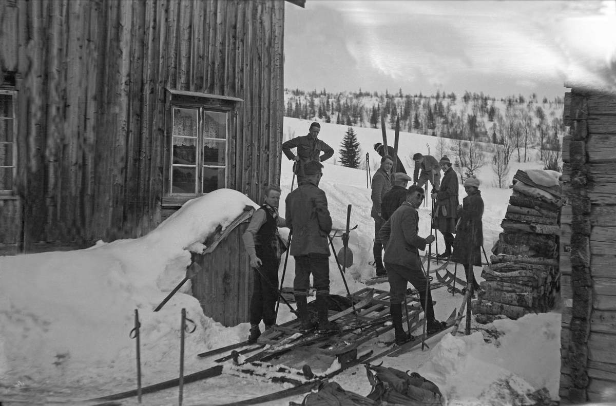 Mange menn og kvinner står med ski på bena ved stasjonen ved Burresjøen, Guldalen. Fotografert påslen 1922.