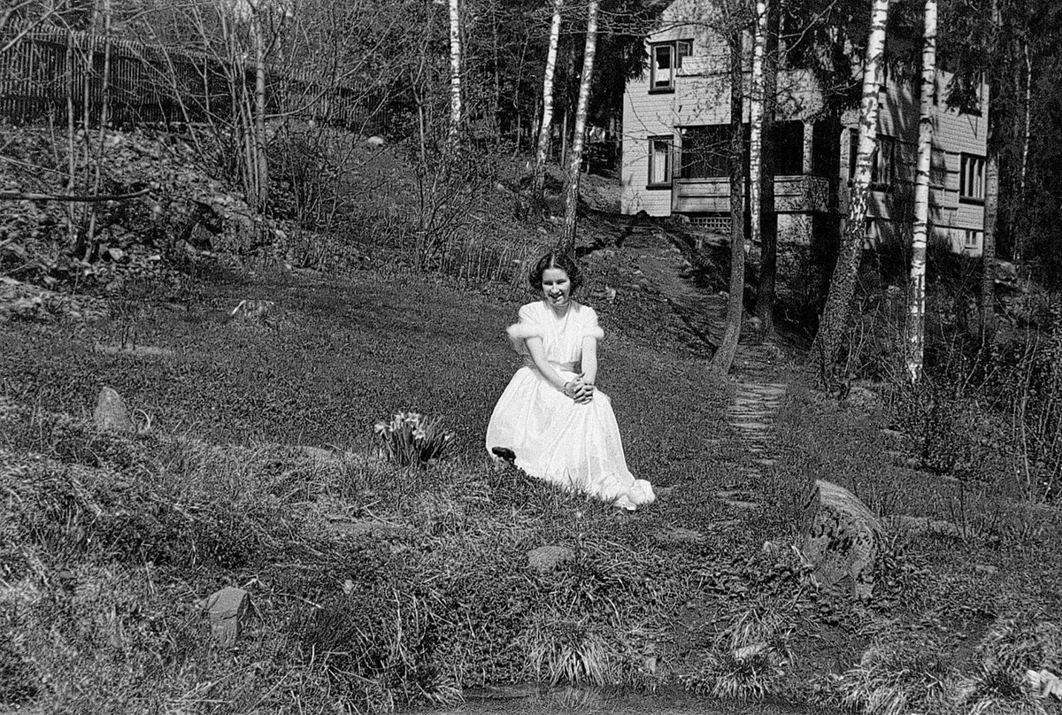Inger Fougli i hagen på Jar, Bærum, Akershus, på konfirmasjonsdagen sin 6. mai 1945. Dette var dagen før freden brøt løs, altså siste dag under krigen. 