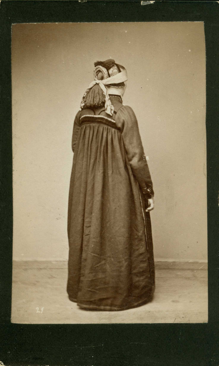 Kvinnedrakt, kone fra Hallingdal, Buskerud. Portrett bakfra av jente/kvinne stående i fotoatelier. Visittkortforat.