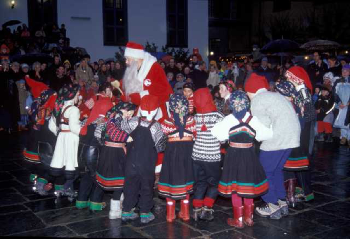Julemarked på Norsk Folkemuseum året 2003. Museets dansegruppe opptrer på torget. Her sammen med julenissen.