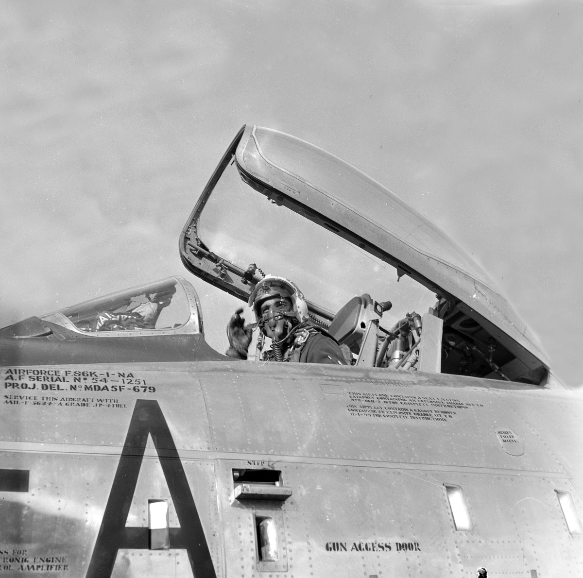 Serie. Mange uniformskledde personer er samlet i anledningen at et jagerfly skal bryte lydmuren. Jagerpiloten sitter i flyet. Fotografert 12. og 13. september 1955.