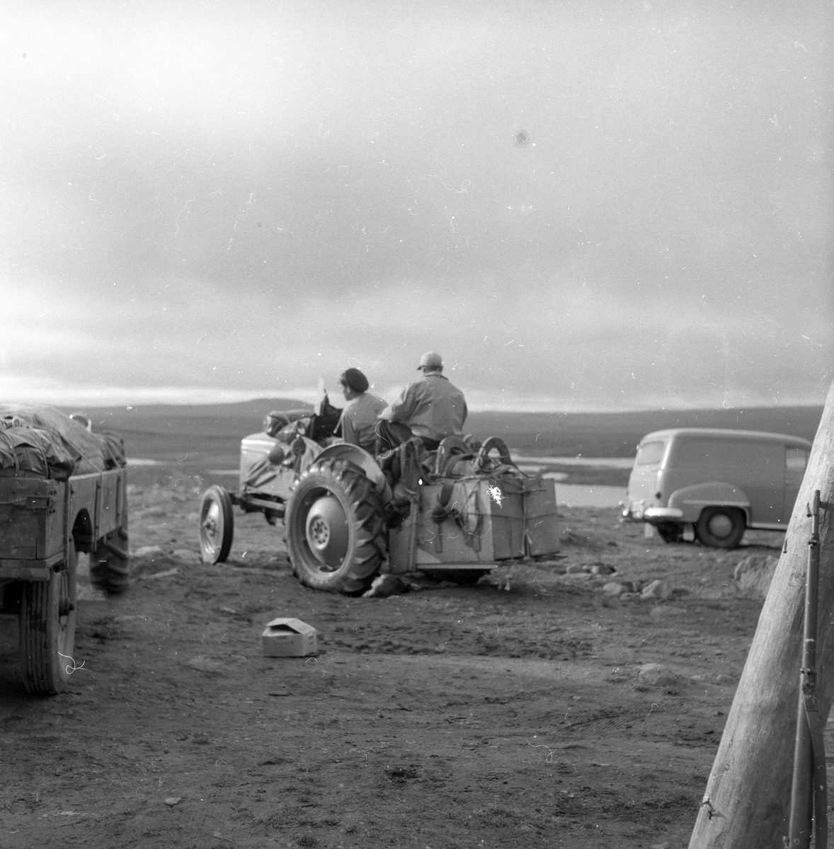 To menn på traktor på villreinjakt på fjellet.
Fotografert 1954.