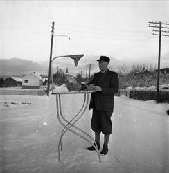 Vang, Oppland, 16.01.1954. Mann ved vei med bord.