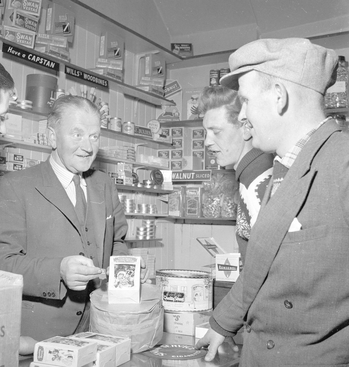 Pigghåfiske på Shetland.
Shetland, 14-22. mai 1958, handling i butikken, kunder og innehaver.