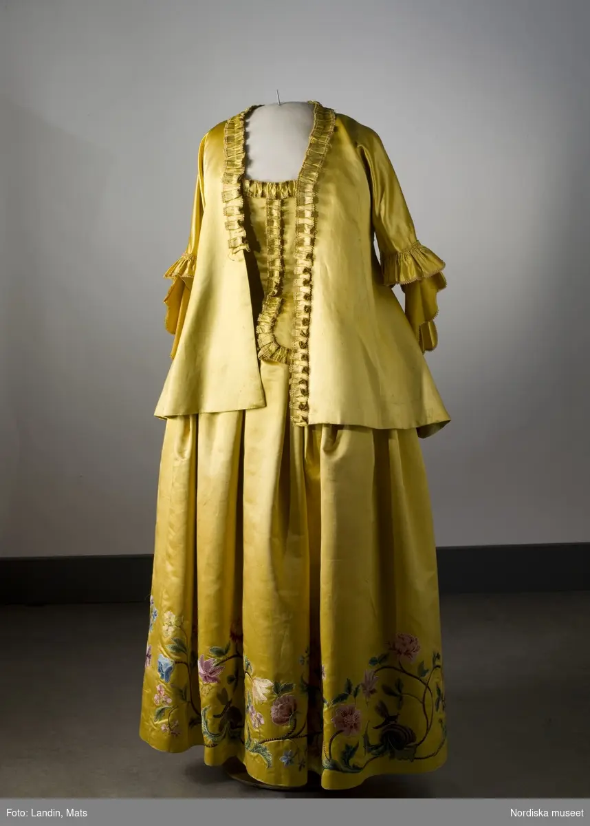 Dräkt av gul atlas med silkebroderier. 1700-talets mitt. Nordiska museet inv nr 171126.