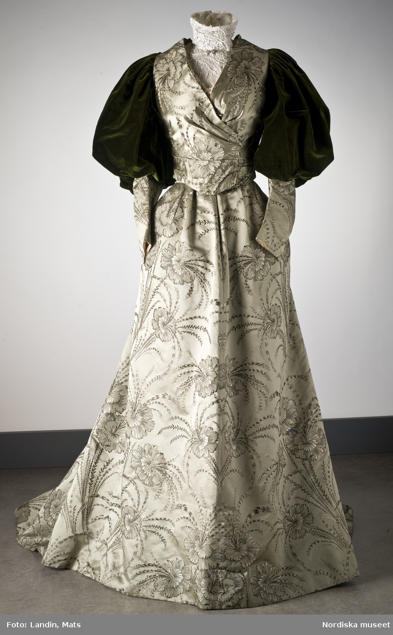 Klänning av grön blomstermönstrad sidendamast. Från 1895. Nordiska museet inv nr 238827.